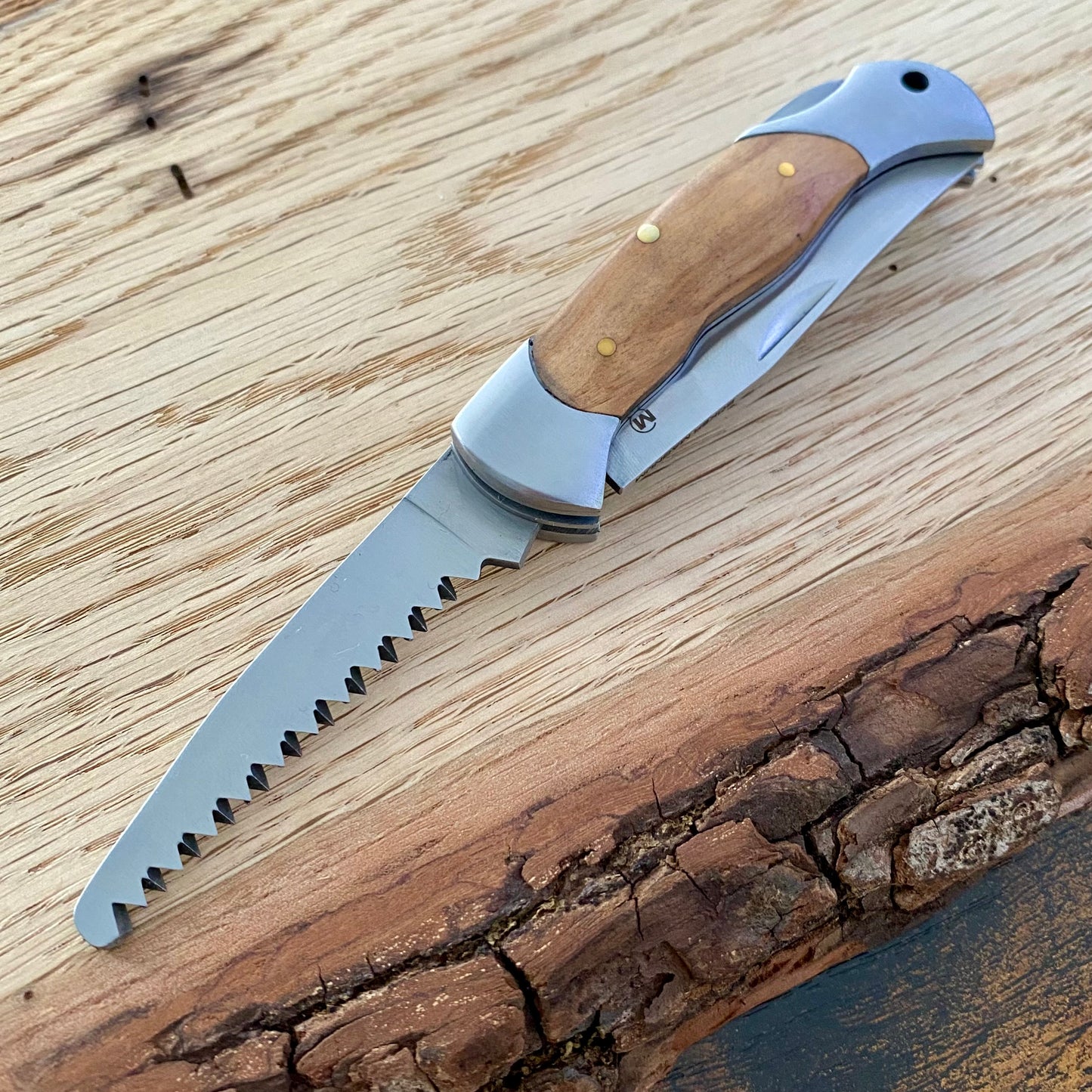 Kindermesser mit abgerundeter Klinge und Säge, Griffschalen aus Holz.