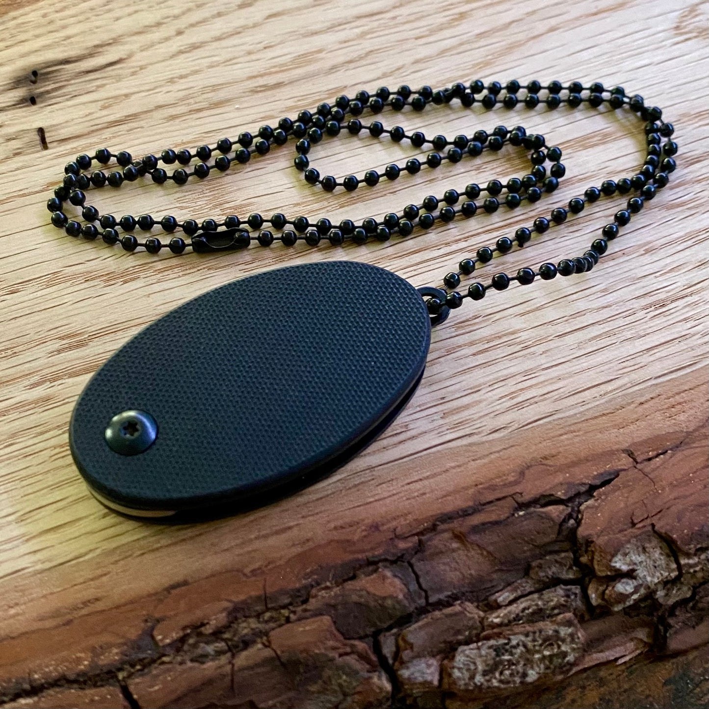 Neck-Knife aus G10 schwarz mit Kugelkette.