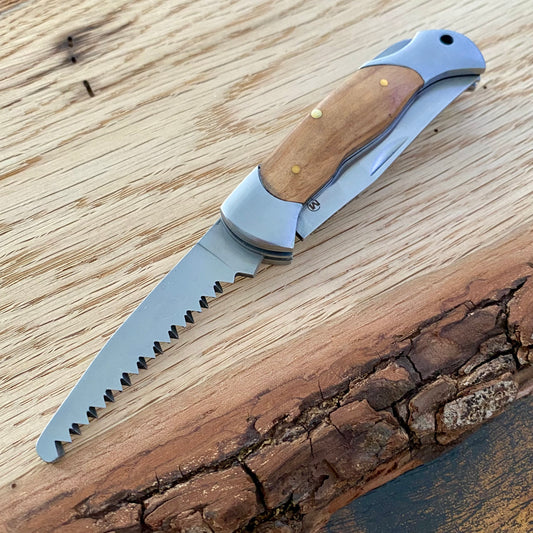 Kindermesser mit abgerundeter Klinge und Säge, Griffschalen aus Holz.