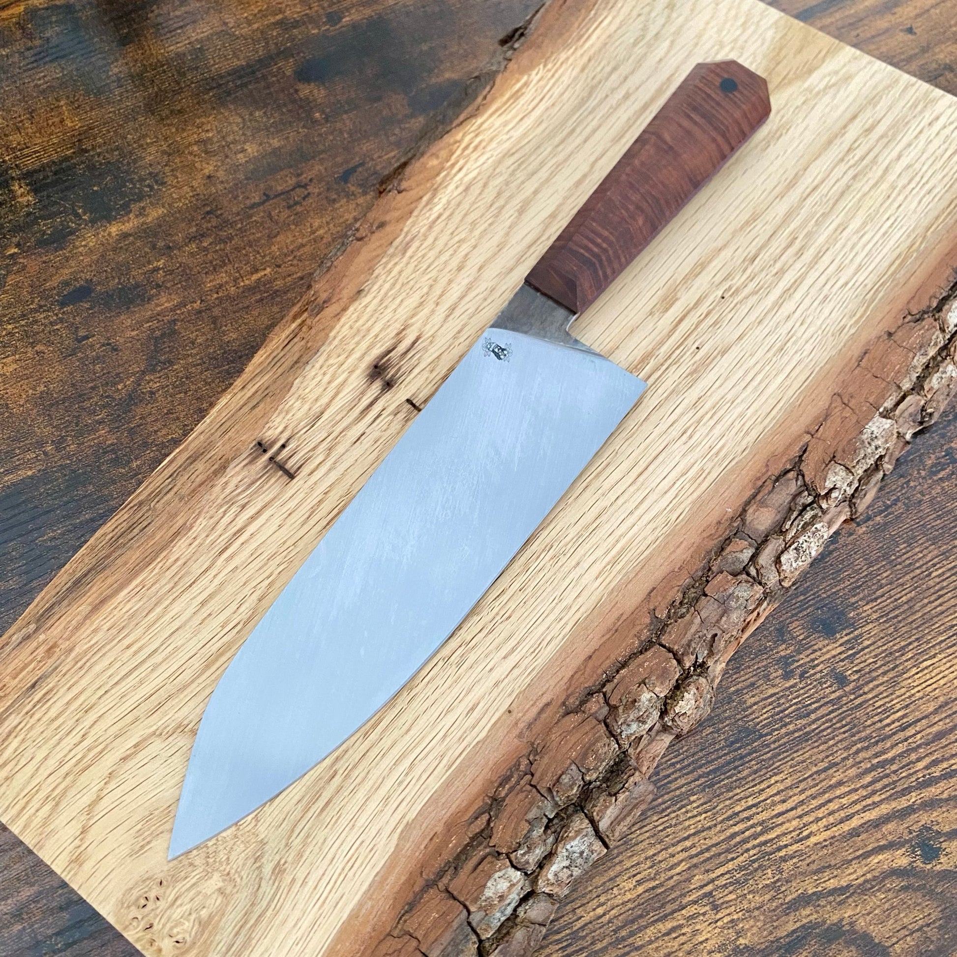 Das Bild zeigt ein handgefertigtes großes Chefmesser von Alb Knives aus Kohlenstoffstahl und einem Griff aus Gidgee-Holz (australische Akazie).